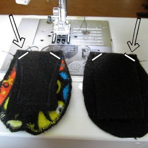 Felt and fabric pieces for making a kids eye patch sitting alongside a sewing machine with white lines and arrows indicating where to sew across each corner.