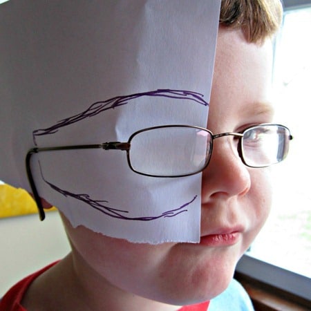 A photo of a child wearing eyeglasses with a piece of paper slid between the eyeglasses and their face and a marker line traced around the eyeglasses on the paper.
