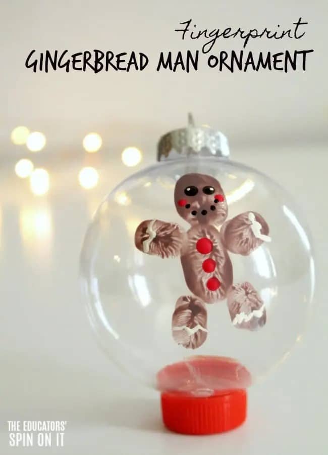 A photo of a preschool ornament craft featuring a clear plastic ball ornament with a cute little painted gingerbread man made out of a child's fingerprints.