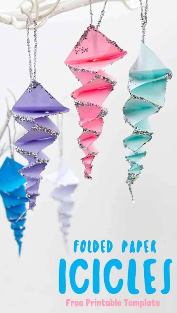 A photo of an easy but pretty paper icicle ornament craft for preschoolers featuring hanging icicle ornaments made out of folded pastel paper and silver glitter.