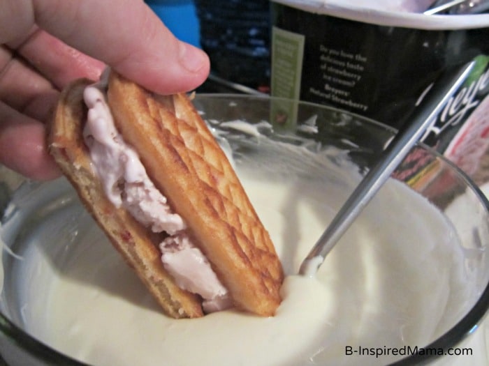 Dipping the Strawberry Waffle Ice Cream Sandwich at B-InspiredMama.com