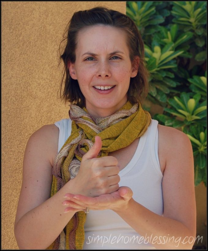 A photo of a mother demonstrating "Help" in Sign Language.