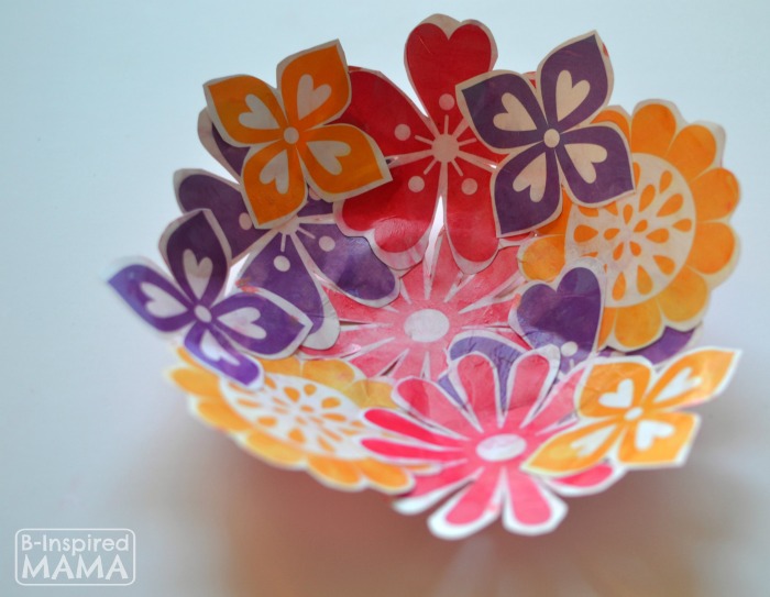 A sweet Mothers Day Paper Bowl craft made out of colorful pink, orange, and purple paper flowers. 
