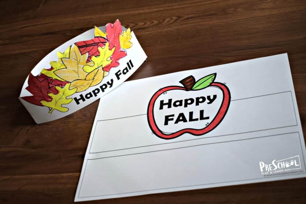 A photo of free Fall preschool printable craft hats in the shape of Autumn leaves and an apple, featuring "Happy Fall".