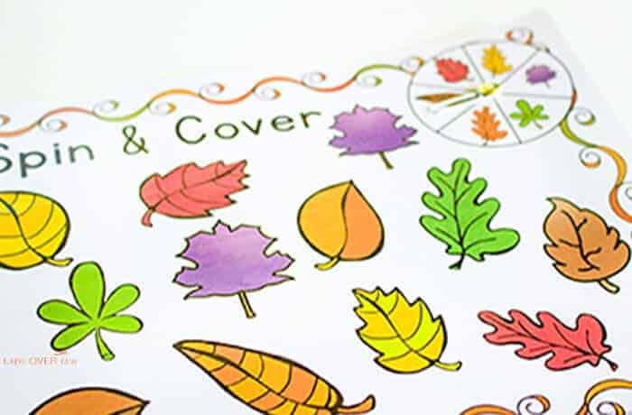 A free printable preschool learning game featuring colorful Autumn leaves and the title "Spin & Color".