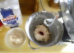 A photo of homemade Candy Cane Peppermint Playdough Recipe being made inside a kitchen stand mixer.