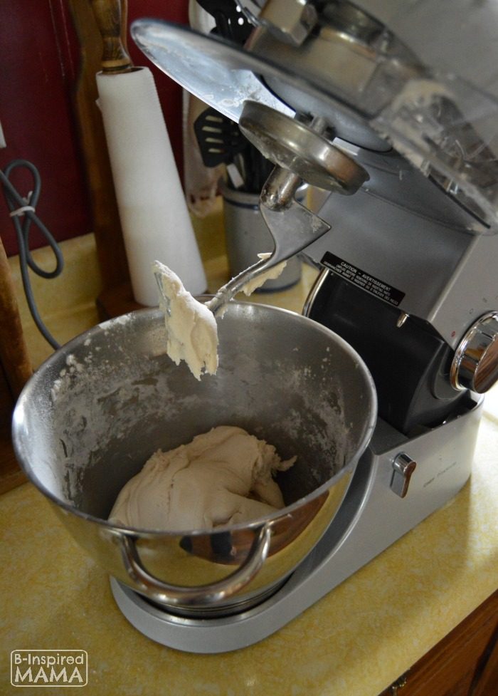 A photo of homemade play dough being made inside a kitchen stand mixer.
