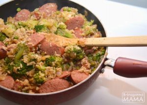 A photo of a frying pan full of a Smoked Sausage and Rice Skillet meal, including sliced Hillshire Farm Smoked Sausage, broccoli, and rice.
