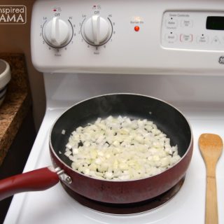 A photo of a frying pan on a stove with chopped onions in it, for a Smoked Sausage and Rice Skillet Recipe.