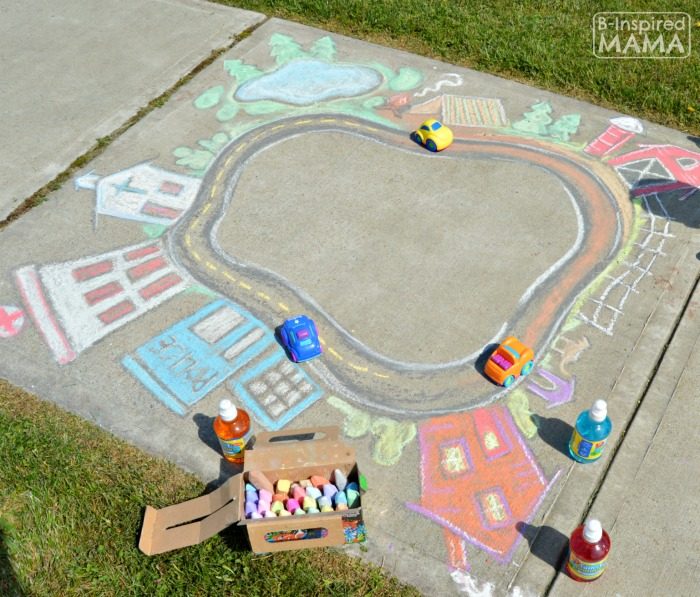 A photo of a giant colorful sidewalk chalk town and road for kids to play cars in.
