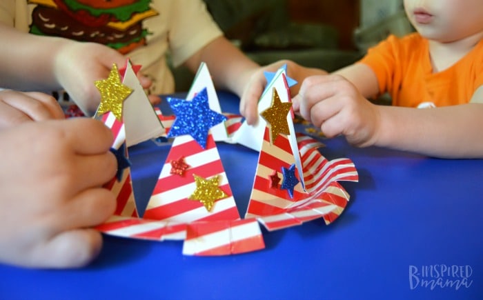 An Easy 4th of July Craft for Kids - A Stars and Stripes Crown - Everyone adding the star stickers - at B-Inspired Mama