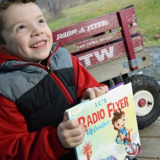 JC surprised to see his name on his My Radio Flyer Adventure Book - at B-Inspired Mama