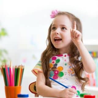 A happy preschool child learning in her classroom.