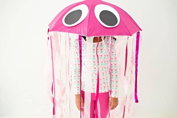 A photo of a young girl wearing a cute homemade jellyfish Halloween costume made from an umbrella hat with streamers.