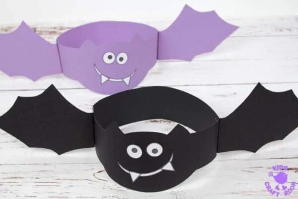 A photo of printable Halloween bat headband crafts made out of black and purple construction paper and printable face features.