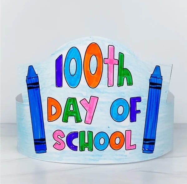 A photo of a free 100th day of school printable headband craft featuring "100th Day of School" and 2 crayons.