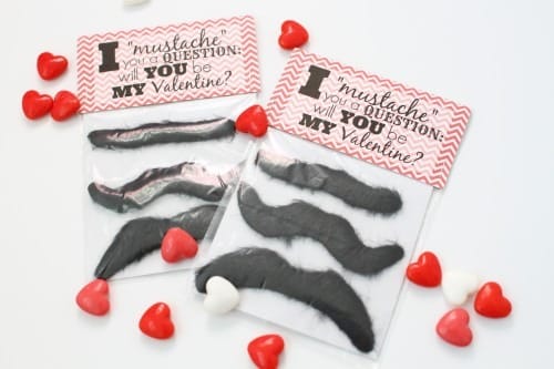 Two free printable Valentine treats featuring silly fake mustaches inside clear treat bags and printable bag toppers with the saying, "I mustache you a question: will you be my Valentine?"